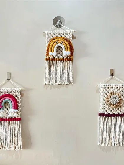 This gallery wall showcases a few of my smaller framed pieces. The set includes two rainbow-themed hangings and a floral medallion, perfect for decorating a cozy corner.