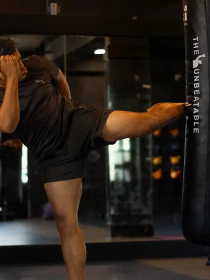 A powerful side kick connecting with the heavy bag. This demonstrates the raw power and proper form we build through consistent training.