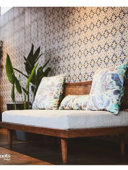 A cozy seating nook is defined by a stunning wall of patterned Moroccan tiles. The wooden bench with plush cushions creates a comfortable and stylish corner, demonstrating how a feature wall can anchor a space.