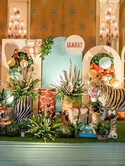 A grand and elaborate jungle safari stage, packed with animal props like a tiger and rhino, character cutouts, and lush greenery.