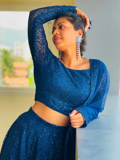 A model posing in a royal blue sequin lehenga, showing off its sparkle and modern design.