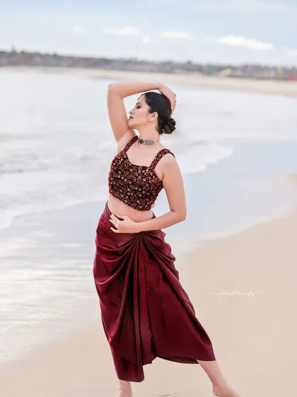 A beachside fashion shoot for a designer's modern-ethnic collection. The models are posed against the sea and coastal rocks to create a windswept, editorial feel that highlights the clothing.