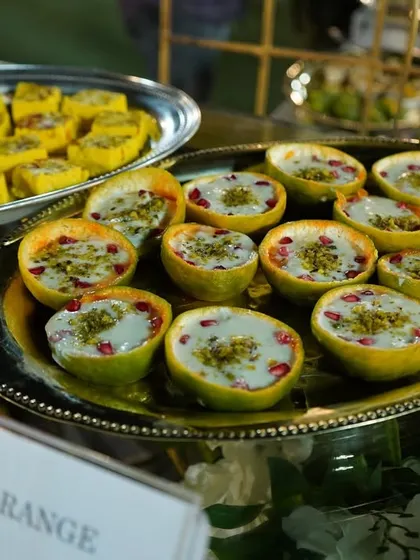 Our "Orange in Orange" dessert is a modern fusion sweet that is as delicious as it is beautiful. A creamy orange-flavored dessert is served inside a hollowed orange peel, topped with pistachios and pomegranate.
