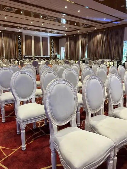 A close-up of the pristine white guest chairs, showcasing the refined furniture choices that elevate the event's ambiance.