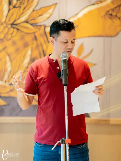 A performer reads from his paper, his gestures adding to the power of his words.