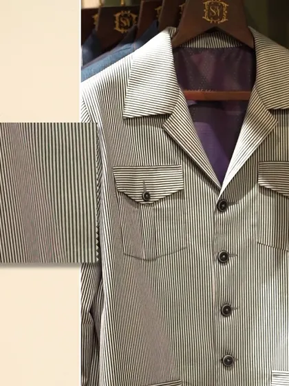 A close-up of a modern striped jacket with utility pockets. The accompanying fabric swatch highlights the texture and precision of the pattern.
