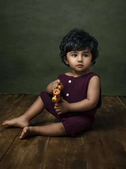 A classic seated portrait of a toddler against a fine art backdrop. This style creates a timeless, painterly image of your growing child.