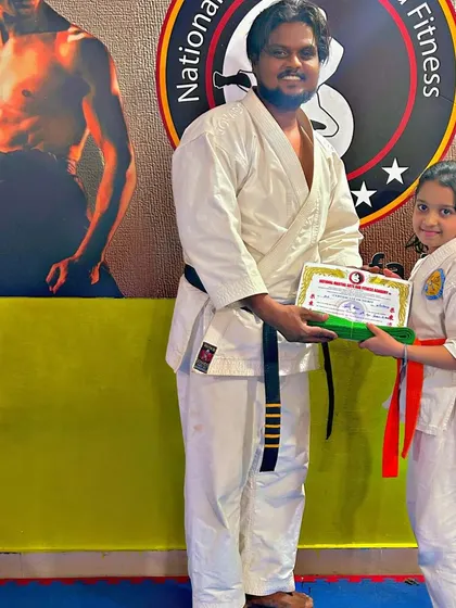 This student is awarded her orange belt, a testament to her hard work and growing Karate skills.