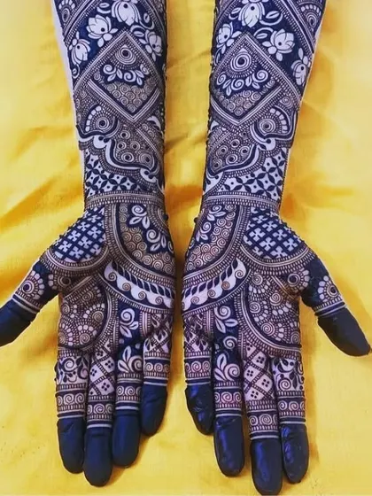 A stunning example of a full-coverage design with a dark, fresh henna application. The contrast and patterns are very bold.