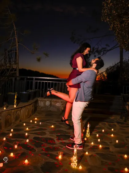 A joyful lift, celebrating their engagement on the candlelit patio. This shot is full of energy and happiness.