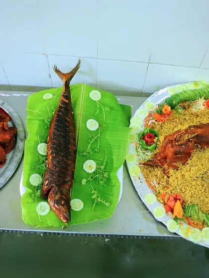 A beautiful spread of our seafood dishes, featuring different types of fried fish and a whole roasted mutton biryani in the background.