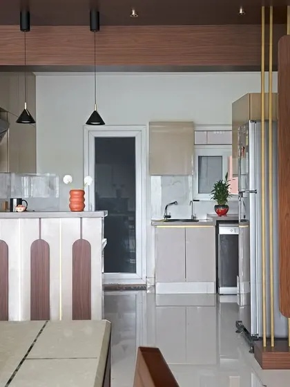 After: The kitchen was reconfigured into an open U-shape with a breakfast bar, modern cabinets, and improved functionality, completely changing the flow of the space.