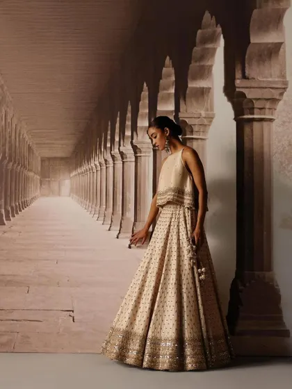 A model styled in a simple yet elegant crop top and lehenga set. The focus here is on the clean lines and intricate border detailing, perfect for a minimalist bride or bridesmaid.