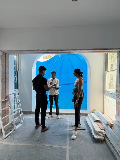A typical team meeting on site. We're discussing the plan for the arched windows and entryways, surrounded by the raw materials that will soon bring it all to life.