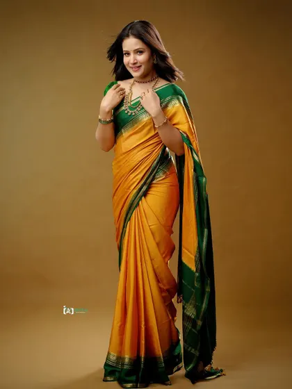 A full-length view that captures the grace of the pose and the vibrant colors of the silk saree. This is a perfect shot for any festive or family occasion.