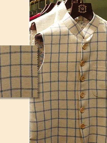 Feel the richness of texture that redefines luxury. A close-up of a checked linen Nehru vest, with a swatch to emphasize the quality of the weave.