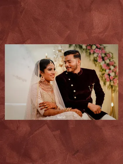 A candid shot of the couple looking at each other during their reception, with beautiful floral arrangements in the background.