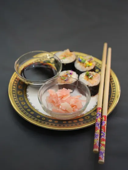A full platter of our Veggie Kimchi Kimbap, served with traditional accompaniments of soy sauce and pickled ginger. It's a wholesome and satisfying dish perfect for any celebration.
