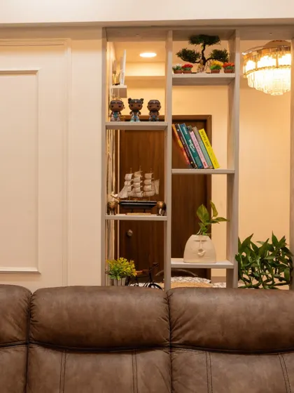 A custom partition in the Pune living room, which acts as a stylish display shelf for books and decor.