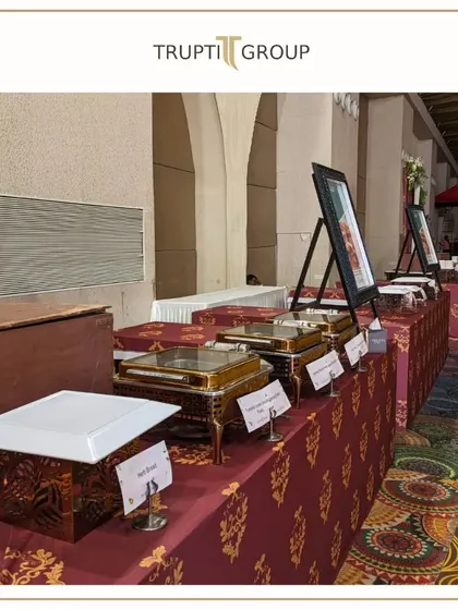 From setup hustle to pre-event cheer. A look at our elegant buffet line with traditional Indian patterned tablecloths and ornate chafing dishes.