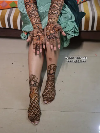 This full bridal look includes portraits on the hands and intricate jaali (net) patterns on the feet, creating a balanced and beautiful design.