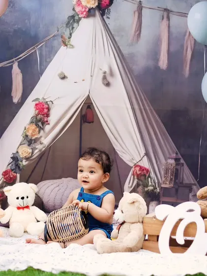 A baby boy playing with a basket in our rustic boho-themed setup.