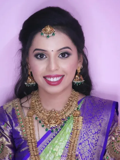 A happy and radiant smile from my client Chaithra. Her makeup is fresh and bright, perfectly complementing her vibrant green and purple saree.