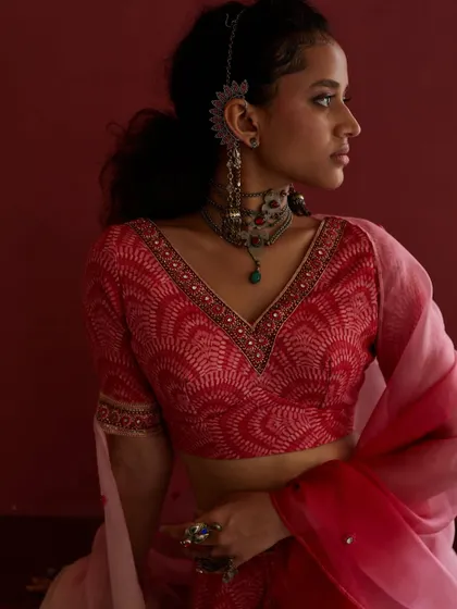 A close-up on the intricate details of a blouse and jewelry. This shot highlights the craftsmanship and artistry of the brand's collection.