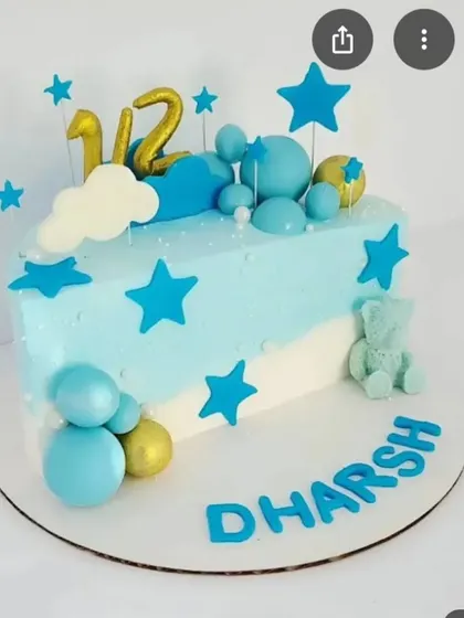 Blue stars, clouds and rounded decorations surround our blue-and-white celebration cake, with a personalised name across the board.