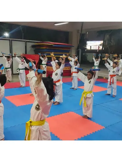 A group of students holding their Nunchaku in a ready stance. This training requires immense focus and discipline.