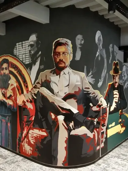 This shot shows the full corner view of 'The Bosses' mural, highlighting its scale and impact on the workspace.