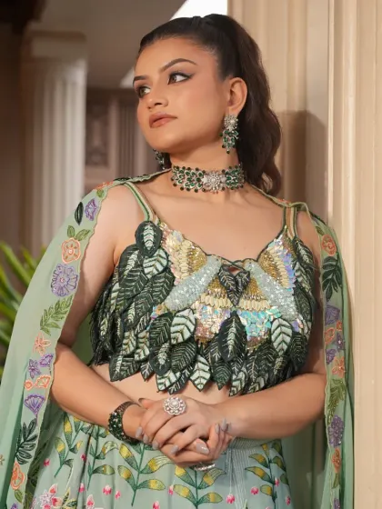 A thoughtful pose in the mint green floral lehenga. The cape-style dupatta with embroidered borders adds a layer of elegance to this beautiful and modern outfit.
