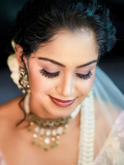 A close-up beauty shot with eyes closed, focusing on the flawless makeup and long lashes, perfect for a makeup artist's portfolio.