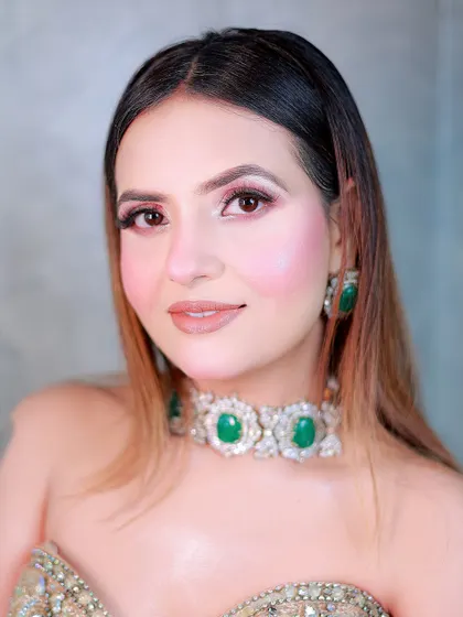 A close-up beauty shot focusing on the soft makeup and the stunning emerald and diamond choker.