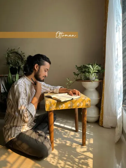 The custom ottoman serves as a small desk in this cozy corner, showing the versatility of custom-made furniture pieces.