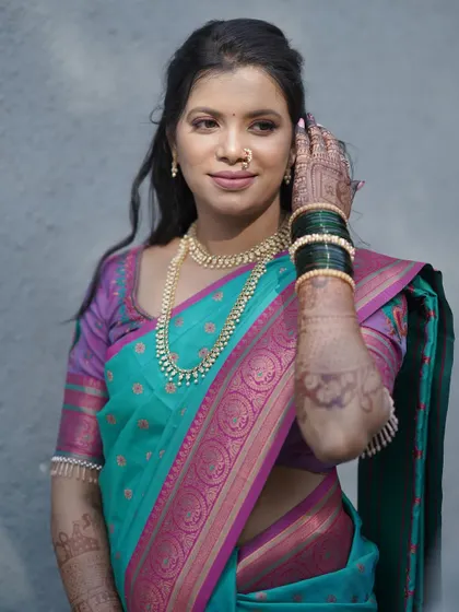 A confident pose from the bride. Her makeup enhances her features, giving her the confidence to shine on her special day.