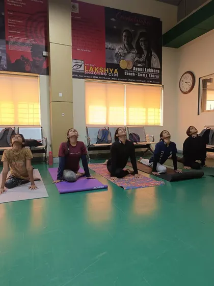 Athletes performing the cobra pose during a yoga session to improve spinal flexibility and relieve stress.