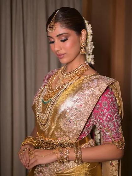 The bride looking down, showcasing the beautiful eye makeup and the intricate details of her temple jewelry. The look is harmonious, with every element working together.