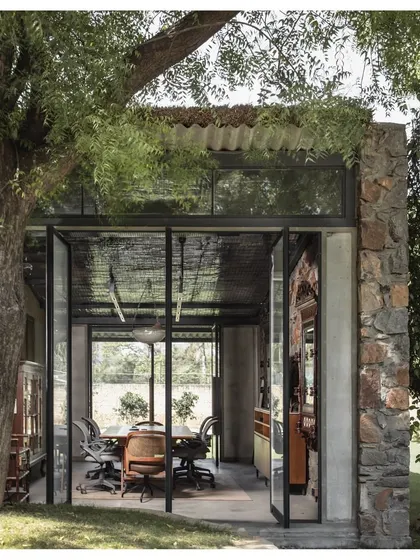 Our own studio is a prime example of our biophilic design philosophy. The workspace is housed in a structure that opens up to the surrounding landscape, with large glass doors that blur the boundary between inside and out.