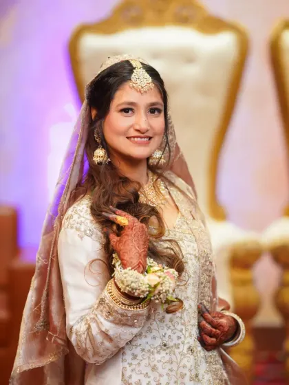 A close-up portrait of the bride, highlighting her intricate henna and floral hand jewelry, key details of her traditional look.