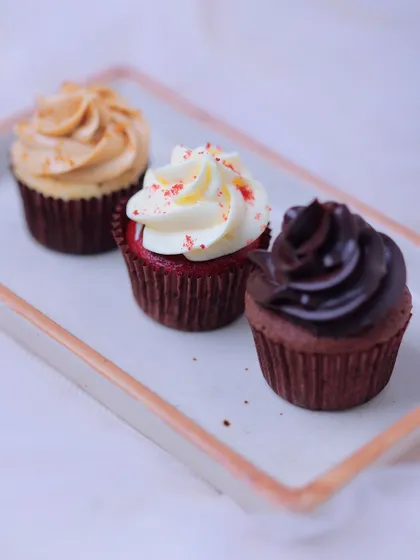 An assortment of our most popular cupcakes: the nutty Biscoff, the classic Red Velvet with cream cheese frosting, and the rich Chocolate Ganache. A perfect trio of flavours.