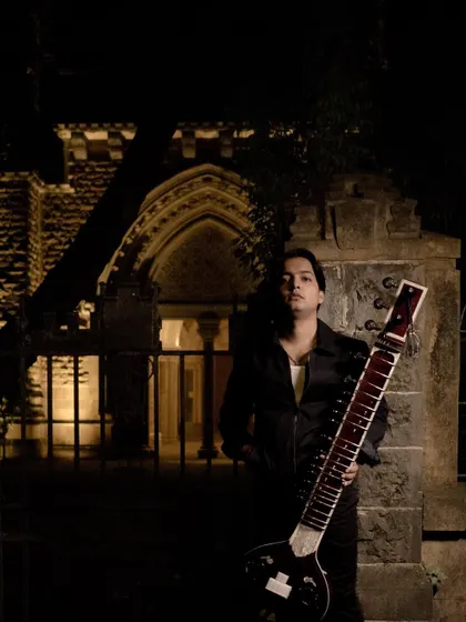 Posing in front of a historic building at night, the perfect backdrop for a fusion track.
