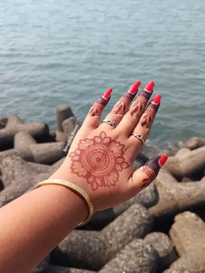 A simple and beautiful mandala mehendi with a rich, dark stain, pictured against the Mumbai sea. This is a perfect, elegant choice for celebrating Diwali.