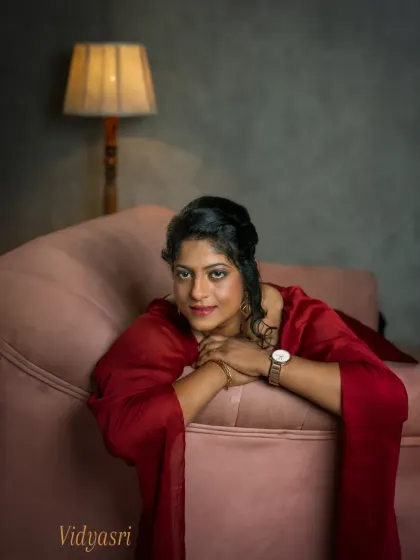A different angle from Vidyasri's session, this portrait includes the warm glow of a vintage lamp. It adds a layer of intimacy and nostalgia to the scene, framing her in a comfortable, reflective moment that feels like a page from her personal story.