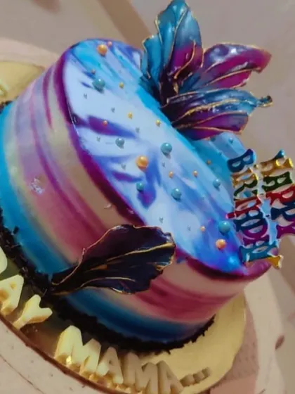 This cake features a stunning marbled glaze in shades of blue and purple. The abstract, artistic finish makes it a unique and eye-catching centerpiece for a birthday.