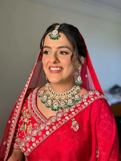 A sleek and polished bridal bun adorned with fresh white flowers. This is a sophisticated and timeless hairstyle, perfect for a bride wearing a pastel pink lehenga.