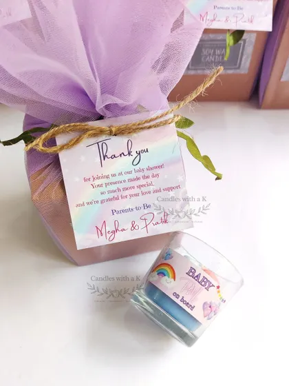 A personalized baby feet votive jar candle for Megha's rainbow-themed baby shower. The custom sticker with a rainbow and 'Baby on board' message makes this a truly unique and memorable favor.