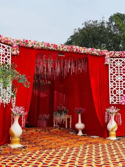 A beautiful entrance view leading to the red stage, with hanging floral arrangements and lattice panels.
