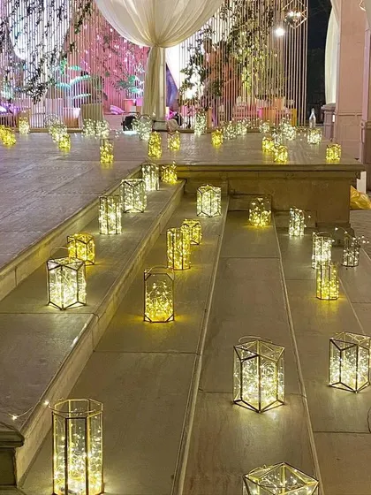 Even stairways become part of the design story. For this elegant reception, the steps were lined with beautiful geometric lanterns filled with fairy lights, creating a warm and welcoming pathway for guests.
