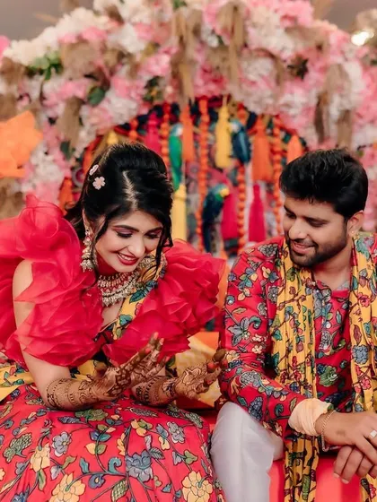 Fun and candid moments from a vibrant Mehendi event. The couple is sharing a laugh, surrounded by the bright, festive atmosphere I designed for their special day.